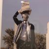 artwork depicting person in student uniform balancing books on head